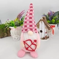 Close-up of pink Valentine gnome plush with red heart arrow and plaid hat decoration - Cupid Arrow Style