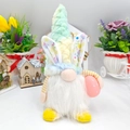 Poupée gnome de Pâques avec oreilles de lapin à fleurs tenant un œuf rose au jardin - Cyan