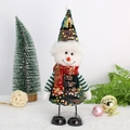 Dettaglio di una bambola di Natale con paillettes verdi e decorazioni festive - Pupazzo di neve
