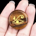 Tiger Eye stone cabochon featuring a golden Eye of Horus engraving in a round design - Tiger's Eye
