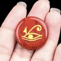 Red jasper stone ornament with golden Eye of Horus symbol shown in hand for scale - Red Jasper