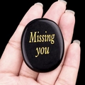 Black oval memorial stone with gold Missing You engraving held in palm for comfort - Obsidian