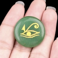 Green aventurine stone with gold Eye of Horus carving held in hand for size - Green Aventurine