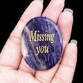 Polished sodalite stone with Missing You gold engraving held in hand - Blue Sodalite