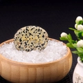 Spotted dalmatian stone with golden Om Mani Padme Hum mantra in a wooden bowl - Dalmatian Jasper