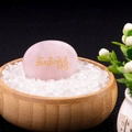 Polished pink crystal palm stone with golden Om Mani Padme Hum engraving on white crystals - Rose Quartz