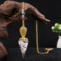Golden hexagonal resin pendulum pendant with white crystal stones on a metal chain - Howlite