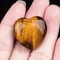 Polished natural tiger eye stone heart pendant with distinct golden brown stripes - Tiger's Eye