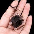 Vintage necklace with raw black tourmaline stone and copper floral setting on black cord - Black Tourmaline