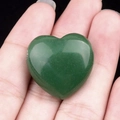 Green Aventurine heart stone pendant held in hand on black background - Green Aventurine