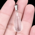 Mano sosteniendo un colgante de gota de cuarzo transparente de 25mm con cierre plata - Cristal de Roca Artificial