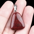 Trapezoid dark reddish brown natural stone pendant with silver metallic texture on fingertip - Rainbow Stone
