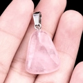 Polished pink rose quartz triangle pendant with silver metal clasp held in hand - Rose Quartz