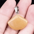 Yellow fan-shaped crystal pendant with silver bail held by hand showing size and texture - 20mm Yellow Jade