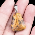 Natural orange agate trapezoid pendant with silver metal clasp held in hand - Crazy Agate