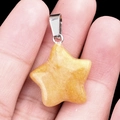 Pendentif étoile en pierre naturelle jaune avec bélière en métal, montré dans la main - Pierre Topaze / 20mm