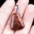 Trapezoid mahogany obsidian stone pendant with silver clasp held in hand for scale - Mahogany Obsidian
