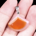 Natural agate fan-shaped pendant with orange gradient finish held in hand - 20mm Red Agate