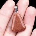 Trapezoid brown goldstone crystal pendant with silver bail shown in hand for size comparison - Gold Sand Stone (Synthetic)
