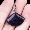 Lapis lazuli blue sandstone fan pendant with silver metal clasp held in hand - 20mm Synthetic Blue Sandstone
