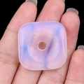 Pendente quadrato in opaline con venature viola e blu tenuto in una mano - Opale (Sintetico)
