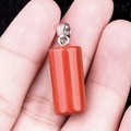 Red jasper cylinder stone pendant with silver clasp held in hand for size visualization - Red Jasper