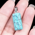Polished turquoise cylinder pendant with black vein pattern on silver metal bail - Blue Turquoise (Synthetic)