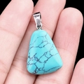 Trapezoid turquoise pendant with natural black veins held in hand for size scale - Blue Turquoise (Synthetic)