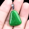 Polished green jade trapezoid pendant with silver metal clasp held in hand - Dyed Malaysian Jade