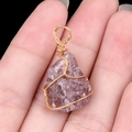 Handmade gold wire-wrapped purple raw crystal pendant with natural stone texture - Strawberry Quartz