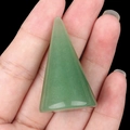 Polished green aventurine stone cone holder for rings held in hand on black background - Green Aventurine
