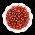 Rote Achatperlen mit großem Loch präsentiert in einer weißen Porzellanschale - 5X10mm Roter Achat