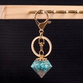 Diamond-shaped keychain with green turquoise stone filling and gold metal ring - Synthetic Turquoise