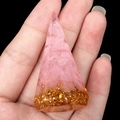 Pyramiden-Ringhalter aus Harz mit rosa Kristallen und Goldfolie auf der Hand gezeigt - Rosenquarz