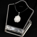 White natural crystal flower pendant with silver bail and black cord on display - Small