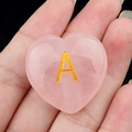 Piedra de corazón de cuarzo rosa natural con letra A dorada grabada en la mano - Letra A