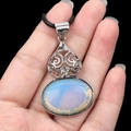 Blue translucent crystal teardrop pendant with silver cutout frame on black rope - Opal (Synthetic)