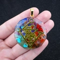 Pendentif hexagonal en résine colorée avec pierres naturelles et runes dorées en main - Design Totem Runique (No. 7)