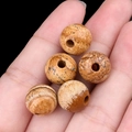 Mano che tiene cinque perle in pietra naturale da 12mm con fori grandi da 3mm e finitura opaca - Diaspro / 12mm con foro da 3mm