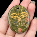 Unakite palm stone pendant featuring a golden all seeing eye symbol on a natural gem - Unakite