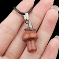 Sparkling goldstone mushroom pendant necklace with black cord on hand model - Gold Sandstone (Artificial)