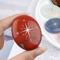 Polished red jasper palm stone with silver compass engraving showing NESW coordinates - Red Jasper