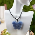 Carved blue natural stone butterfly pendant necklace with black woven cord on a display - Blue Aventurine Style