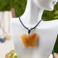 Carved yellow tiger eye butterfly pendant necklace on white mannequin with green background - Yellow Jade Style