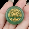 Green aventurine stone pendant with golden tree of life carving held in hand - Green Aventurine