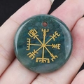 Moss agate Viking Vegvisir pendant with gold-colored engraving shown in hand - India Agate