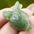 Hand-carved green aventurine fox head figurine displayed on palm for scale - India Agate