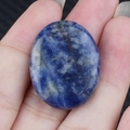 Pietra di sodalite blu naturale ovale lucida tenuta in mano per guarigione energetica - Sodalite Blu