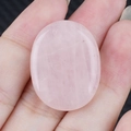 Pietra di quarzo rosa ovale lucidata con trama di cristallo naturale nella mano - Quarzo rosa