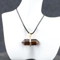Double pointed hexagonal tiger eye stone necklace with gold finish on a black cord - Tiger's Eye